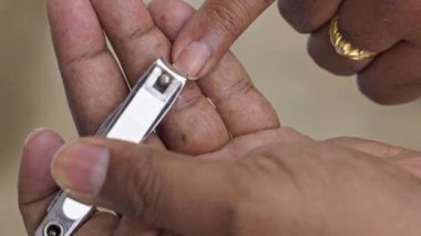 Tırnaklarını kesmek için tırnak makası kullanan bir adama yaklaş. Adam tırnaklarını kesiyor. Tırnak kesme ve oje sürme. Hijyenin kısaltılmışı.