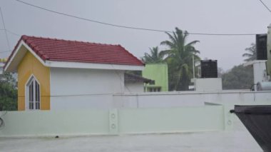 Yağmurlu bir günde binanın çatısına sağanak yağmur yağıyor. Şehirde yağmur yağıyor. Kötü hava. Şehirde sağanak var.