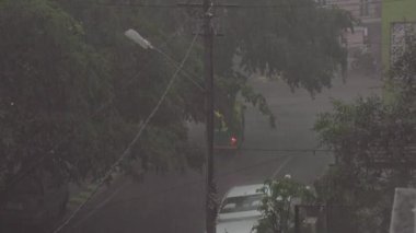 Balkondan bakınca Bangalore caddesinde sağanak yağış görülüyor. Şehirde yağmur yağıyor. Kötü hava. Şehirde sağanak var.