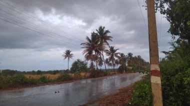 Köyün yolunda güzel bir yağmur manzarası. Küçük bir Hint köyünde sağanak yağmur mevsimi.