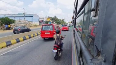 Bangalore, Hindistan-28 Nisan 2023: Otobüsün penceresinden yapılan bir görüntü, yaz aylarında seyahat sırasında otoyolda araçların geçişini veya aceleye getirilmesini gösteriyor