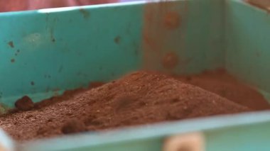 Tütsü konileri hazırlamak için tütsü fabrikasında karıştırıcıya veya miksere sandal ağacı tozu dökmek. Tütsü konisi üretimi.