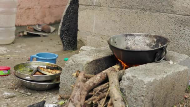 伝統的なスタイルでレンガのストーブの上で鍋に魚片をフライパンの閉鎖 食べ物はレンガのストーブの中で木を燃焼することによって調理されています 薪火料理 — ストック動画