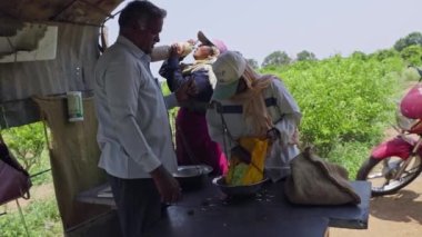 Vijayanagara, Hindistan-16 Nisan 2023: Bir çiftçi tarafından tartılan toplanan yasemin çiçeklerinin yazın işçiler için maaşları hesaplaması. Hasat ve ihracat