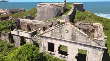 Brezilya sömürge imparatorluk döneminden kalma ıssız bir kayalık adada, deniz ile çevrili terk edilmiş eski bir tuğla ve taş kalenin insansız hava aracı görüntüsü.