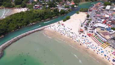 Florianpolis, Santa Catarina, Brezilya 'daki Barra da Lagoa kanalı ve plajının hava aracı görüntüsü, tatlı suyun denizden tuzlu suyla buluştuğu kanalda kesiştiği iki tekne.
