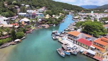 Barra da Lagoa Kanalı 'nın havadan görünüşü ve gölde tekneleri olan balıkçı topluluğu, Florianpolis, Santa Catarina, Brezilya, Lagoa da Conceicao haliçlerindeki birçok ev