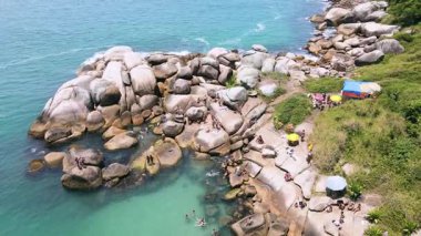 Florianpolis, Santa Catarina 'daki Barra da Lagoa' daki doğal havuz manzarası. Dağ yamacındaki büyük kayalar turkuaz ve zümrüt yeşili okyanusla birleşiyor.