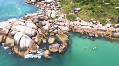 Florianpolis, Santa Catarina 'daki Barra da Lagoa' daki doğal havuzun hava aracı görüntüsü. Dağ yamacındaki büyük kayalar turkuaz ve zümrüt yeşili okyanusla birleşiyor.
