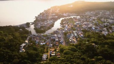 Florida, Brezilya 'daki Lagoa da Conceio ve Barra da Lagoa kanallarındaki dağların ardında gün batımını gösteren hava aracı görüntüsü..