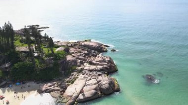 Florianopolis, Santa Catarina 'daki Joaquina Sahili' nin kayalık kıyı şeridinin panoramik hava manzarası turkuvaz mavisi deniz ile güneşli bir yaz günü