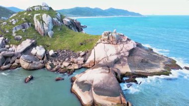 Florianopolis, Santa Catarina, Brezilya 'daki Gravata Sahili' nin kayalık sahili, kaya, doğa ve turkuaz bir okyanusa sahip bol Atlantik Ormanı ile dolu bir ejderha kafası..