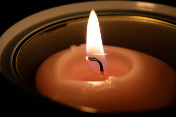 close up of a candle in a dark interior.