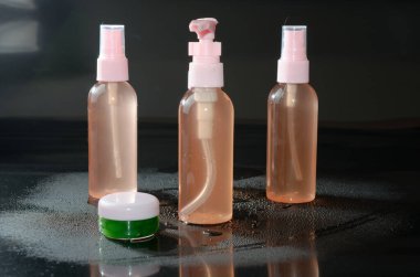 Siyah zemin üzerinde sıvı bulunan üç şişenin yakın plan çekimi.