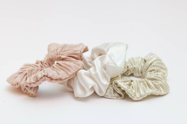beige silk scrunchies on white. Luxury hairdressing tools for girls perfect for all hair types. elastic hair tie accessories.