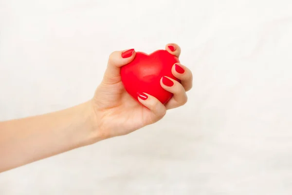 woman hand with red manicure holding red heart on white. Nurses caring Heart. Good Health Support and Protection Business Hospital Private Service Concept.