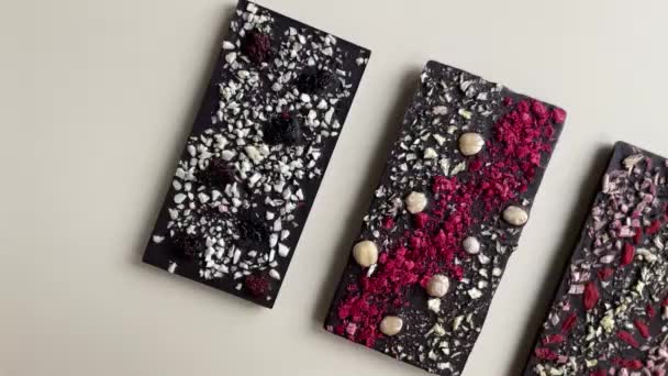 手工制作的带有坚果和浆果的黑巧克力条 顶部的米色背景画面 高质量的4K镜头 — 图库视频影像