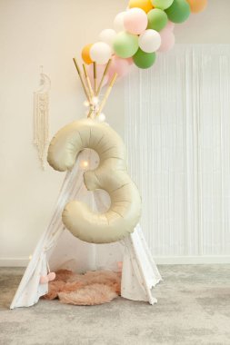 Ağaç çocuk odasında. Doğum günü süslemeleri - Colofrul balonları beyaz duvar arkasında çelenk partisi.