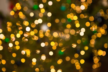 Noel ağacında bulanık altın bir çelenk, çözülmüş bir arka plan. Noel soyutlaması. Noel yeşili arka planda altın bokeh. Noel ağacı ışıkları