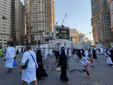 Mescid-i Haram, Mekke ve Suudi Arabistan 'ın dış avlusundaki güvercinler hacıların sunduğu tahılları yiyorlar..