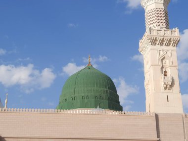 Beautiful daytime view of Masjid Al Nabawi, Medina's minarets and mosque courtyard.