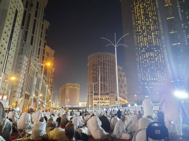 Mescid-i Haram 'ın dış yolundaki hacıların, yüksek binaların ve ışıkların güzel manzarası..