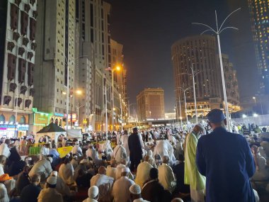 Mescid-i Haram 'ın dış yolundaki hacıların, yüksek binaların ve ışıkların güzel manzarası..