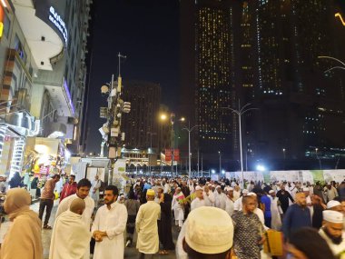 Mescid-i Haram 'ın dış yolundaki hacıların, yüksek binaların ve ışıkların güzel manzarası..