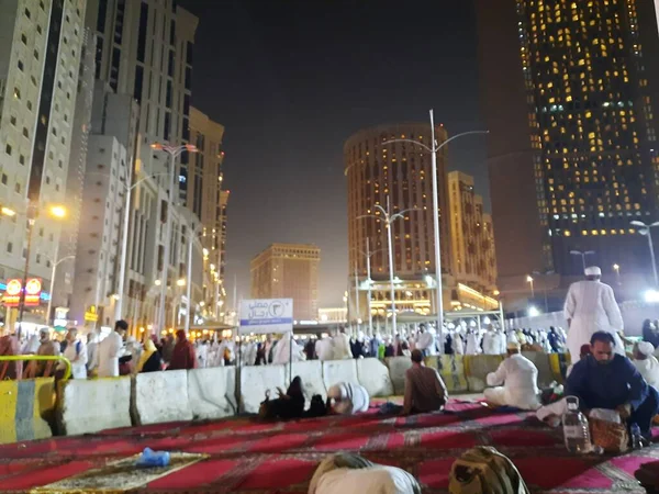 Mescid-i Haram 'ın dış yolundaki hacıların, yüksek binaların ve ışıkların güzel manzarası..