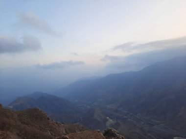 Abha şehrinin tepelerine doğru nefes kesici bir akşam manzarası Suudi Arabistan, Abha 'da yaşanabilecek en büyüleyici deneyimlerden biri High City olarak bilinen yüksek noktadan gün batımına tanıklık etmektir..