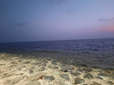 Güneş batarken Jizan Corniche 'in göz kamaştırıcı akşam manzarası. Titrek gökyüzü ve ışıldayan su resim gibi bir manzara yaratır..