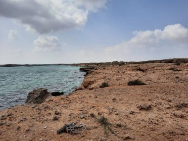  Suudi Arabistan, Jazan 'daki Farasan Adaları' nın çarpıcı panoramik manzarası. Şeffaf sular, kayalık oluşumlar ve yaklaşan kara bulutlar muhteşem bir manzara yaratır..