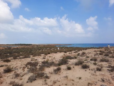 Suudi Arabistan, Jazan 'daki Farasan Adaları' nın çarpıcı panoramik manzarası. Şeffaf sular, kayalık oluşumlar ve yaklaşan kara bulutlar muhteşem bir manzara yaratır..