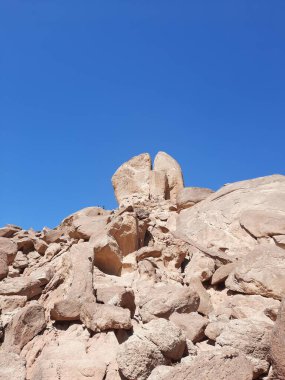 Al Bada, Tabuk 'taki Split Rock of Horeb çevresindeki dağların çarpıcı gündüz görüntüsü. Split Horeb Kayası, batıda Tabuk bölgesinde Al Bada yakınlarında bulunan Jabal Al Lawz üssünde yer almaktadır..