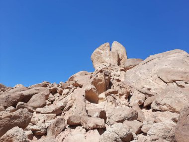 Al Bada, Tabuk 'taki Split Rock of Horeb çevresindeki dağların çarpıcı gündüz görüntüsü. Split Horeb Kayası, batıda Tabuk bölgesinde Al Bada yakınlarında bulunan Jabal Al Lawz üssünde yer almaktadır..