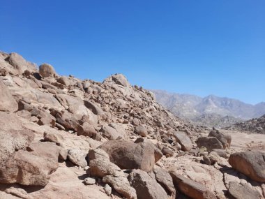 Al Bada, Tabuk 'taki Split Rock of Horeb çevresindeki dağların çarpıcı gündüz görüntüsü. Split Horeb Kayası, batıda Tabuk bölgesinde Al Bada yakınlarında bulunan Jabal Al Lawz üssünde yer almaktadır..
