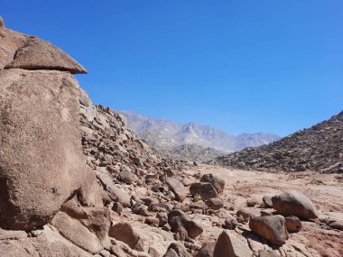Al Bada, Tabuk 'taki Split Rock of Horeb çevresindeki dağların çarpıcı gündüz görüntüsü. Split Horeb Kayası, batıda Tabuk bölgesinde Al Bada yakınlarında bulunan Jabal Al Lawz üssünde yer almaktadır..