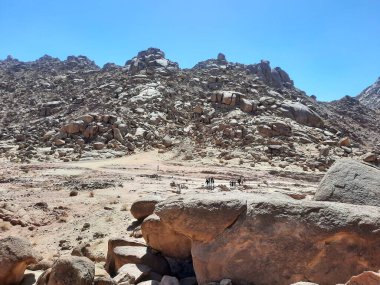 Al Bada, Tabuk 'taki Split Rock of Horeb çevresindeki dağların çarpıcı gündüz görüntüsü. Split Horeb Kayası, batıda Tabuk bölgesinde Al Bada yakınlarında bulunan Jabal Al Lawz üssünde yer almaktadır..