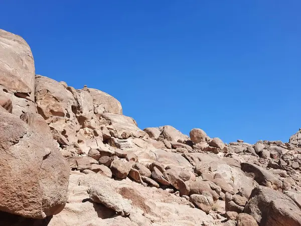 Al Bada, Tabuk 'taki Split Rock of Horeb çevresindeki dağların çarpıcı gündüz görüntüsü. Split Horeb Kayası, batıda Tabuk bölgesinde Al Bada yakınlarında bulunan Jabal Al Lawz üssünde yer almaktadır..