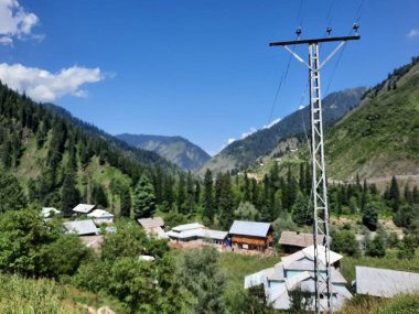  Kaşmir 'in Neelum Vadisi' ndeki Halmat köyünün göz kamaştırıcı bir perspektifi. Canlı yeşil ağaçlar, görkemli dağlar ve bol bitki örtüsü manzaralı bir manzara yaratır..