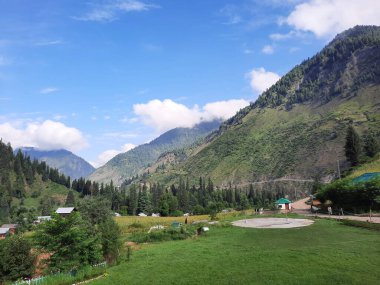  Kaşmir 'in Neelum Vadisi' ndeki Halmat köyünün göz kamaştırıcı bir perspektifi. Canlı yeşil ağaçlar, görkemli dağlar ve bol bitki örtüsü manzaralı bir manzara yaratır..