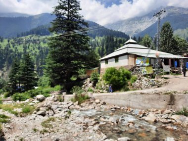 Yeşil manzaralardan, yüksek tepelerden ve gelişen ağaçlardan oluşan büyüleyici bir gündüz manzarası Kashmir 'in Neelum Vadisi' ndeki Jagran Vadisi 'nde tünemiş olan Shal köyünün etrafını sarmış durumda..