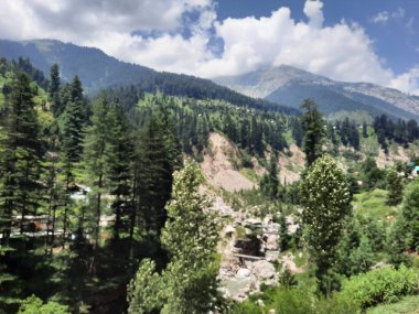 Yeşil manzaralardan, yüksek tepelerden ve gelişen ağaçlardan oluşan büyüleyici bir gündüz manzarası Kashmir 'in Neelum Vadisi' ndeki Jagran Vadisi 'nde tünemiş olan Shal köyünün etrafını sarmış durumda..