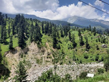 Yeşil manzaralardan, yüksek tepelerden ve gelişen ağaçlardan oluşan büyüleyici bir gündüz manzarası Kashmir 'in Neelum Vadisi' ndeki Jagran Vadisi 'nde tünemiş olan Shal köyünün etrafını sarmış durumda..