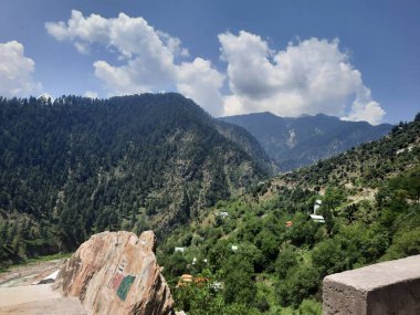 Yeşil manzaralardan, yüksek tepelerden ve gelişen ağaçlardan oluşan büyüleyici bir gündüz manzarası Kashmir 'in Neelum Vadisi' ndeki Jagran Vadisi 'nde tünemiş olan Shal köyünün etrafını sarmış durumda..