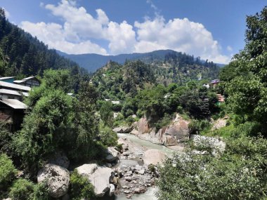 Yeşil manzaralardan, yüksek tepelerden ve gelişen ağaçlardan oluşan büyüleyici bir gündüz manzarası Kashmir 'in Neelum Vadisi' ndeki Jagran Vadisi 'nde tünemiş olan Shal köyünün etrafını sarmış durumda..