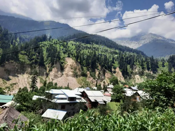 Yeşil manzaralardan, yüksek tepelerden ve gelişen ağaçlardan oluşan büyüleyici bir gündüz manzarası Kashmir 'in Neelum Vadisi' ndeki Jagran Vadisi 'nde tünemiş olan Shal köyünün etrafını sarmış durumda..
