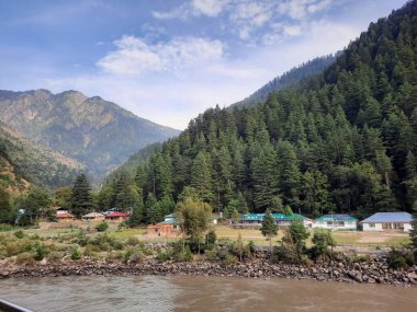 Kaşmir 'deki Neelum Vadisi' nin göz kamaştırıcı gündüz manzarası. Kaşmir 'deki Neelum Vadisi nefes kesici bir yerdir. Bereketli yeşil manzarası, uzun ağaçları ve canlı yeşilliği cennete benzer bir manzara yaratır..