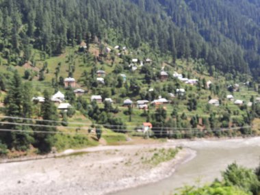 Kaşmir 'deki Neelum Vadisi' nin göz kamaştırıcı gündüz manzarası. Kaşmir 'deki Neelum Vadisi nefes kesici bir yerdir. Bereketli yeşil manzarası, uzun ağaçları ve canlı yeşilliği cennete benzer bir manzara yaratır..