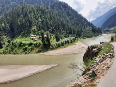 Kaşmir 'deki Neelum Vadisi' nin göz kamaştırıcı gündüz manzarası. Kaşmir 'deki Neelum Vadisi nefes kesici bir yerdir. Bereketli yeşil manzarası, uzun ağaçları ve canlı yeşilliği cennete benzer bir manzara yaratır..